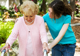 young woman assisting senior woman in walking